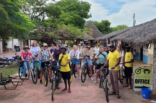 Groep reizigers staat klaar met fietsen en gidsen voor de fietstour bij Diani Beach in Kenia