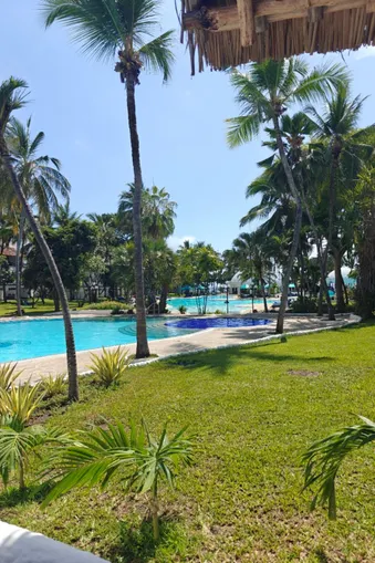 Uitzicht op het zwembad en de Indische Oceaan omringd door palmbomen bij Baobab Beach Resort in Kenia